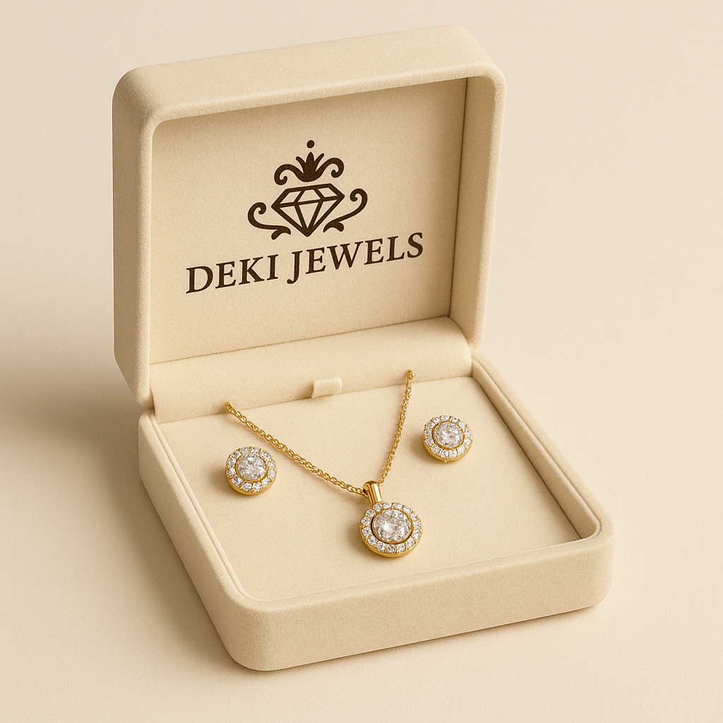 Gold jewelry set with necklace and earrings in a 'DEKI JEWELS' box on a beige background